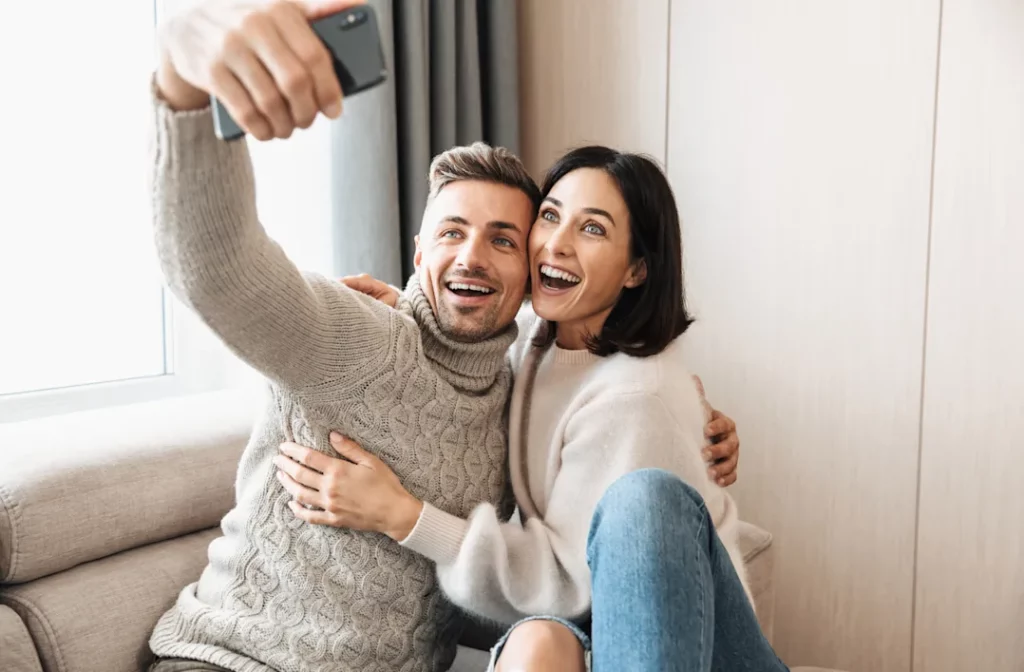 Couple taking a selfie together and smiling.